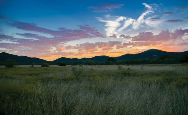 The sun setting below mountains.