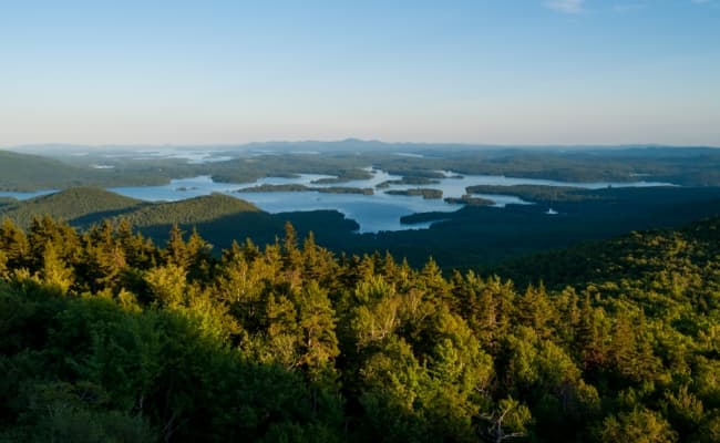 An aerial view of New Hampshire lakes surrounded by lush forest.