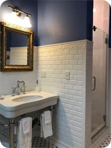 A modern bathroom with a sink, mirror, lighting and a shower