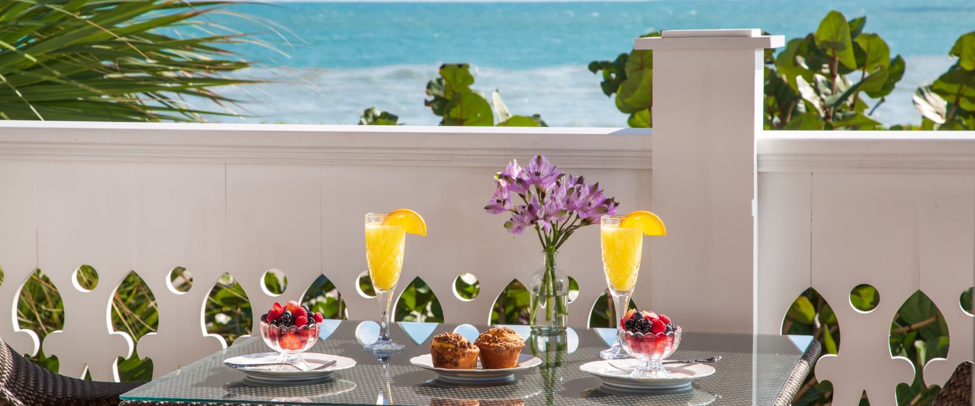 breakfast on a table on a porch overlooking the water