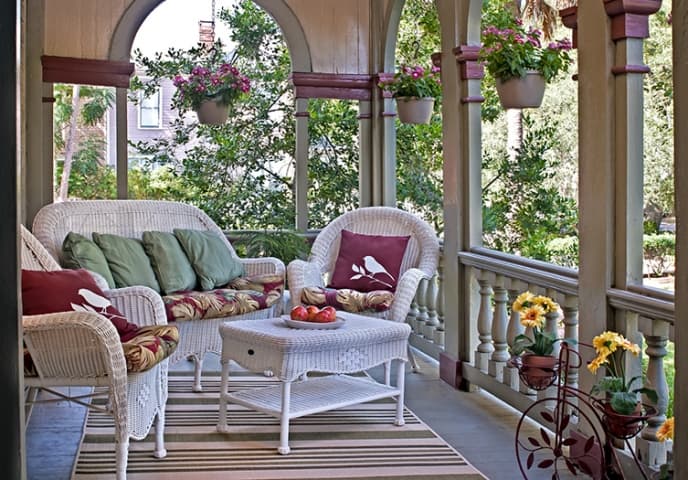 Front porch with wicker table, couch and chair