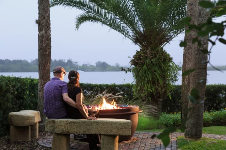 couple by fireplace looking at water views