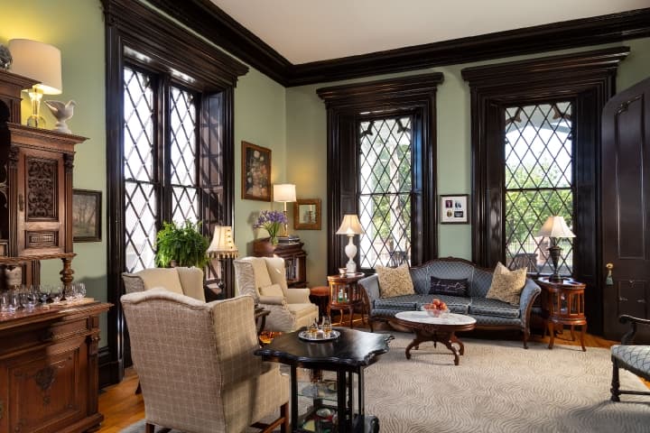 living room with tall gothic windows and antique furniture