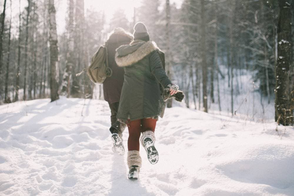A couple playing in the snow during romantic getaways in New England