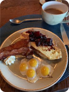 Plate with eggs, bacon and toast with jam